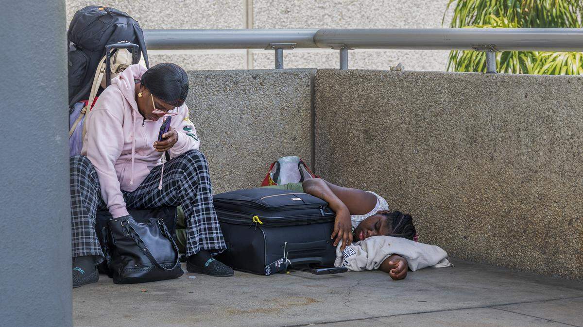 Passenger Esteen Henry and her granddaughter Kerifa sit outside of Terminal 3 at Fort Lauderdale-Hollywood International Airport after their Spirit Airlines flight to St. Thomas was canceled after the airline shut down overnight on Saturday, May 2, 2026. Passenger Esteen Henry and her granddaughter Kerifa sit outside of Terminal 3 at Fort Lauderdale-Hollywood International Airport after their Spirit Airlines flight to St. Thomas was canceled after the airline shut down overnight on Saturday, May 2, 2026.
